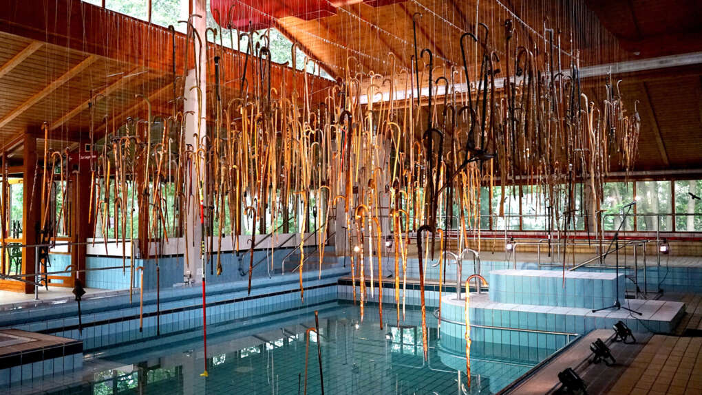 Ausstellung Spazierstöcke an der Decke über dem Becken im ehemaligen Badehaus Maiersreuth