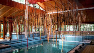 Ausstellung Spazierstöcke an der Decke über dem Becken im ehemaligen Badehaus Maiersreuth
