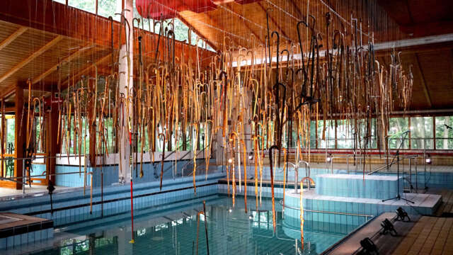 Ausstellung Spazierstöcke an der Decke über dem Becken im ehemaligen Badehaus Maiersreuth