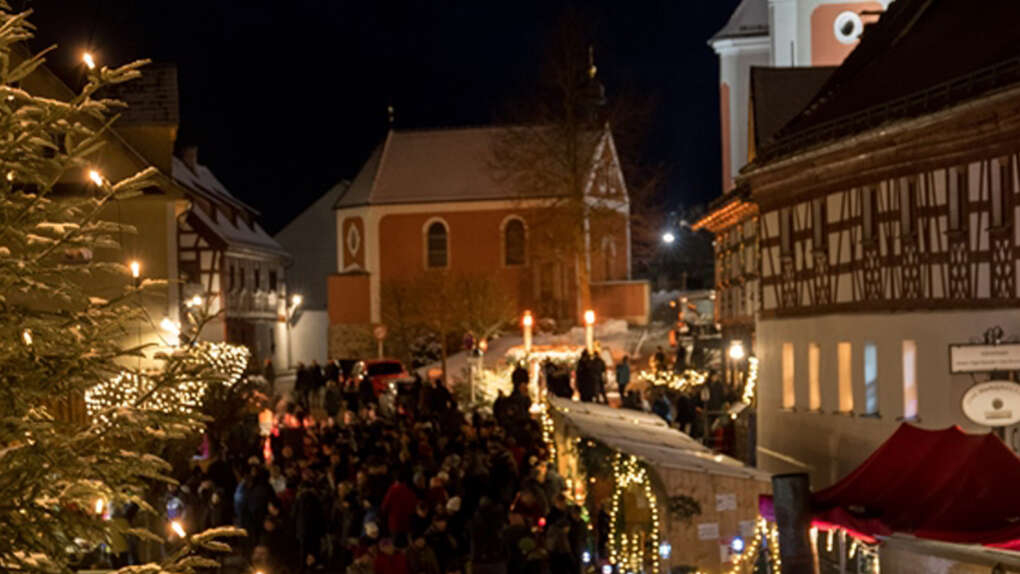 Marktplatz mit Buden und Lichtern am Kunsthandwerkermarkt